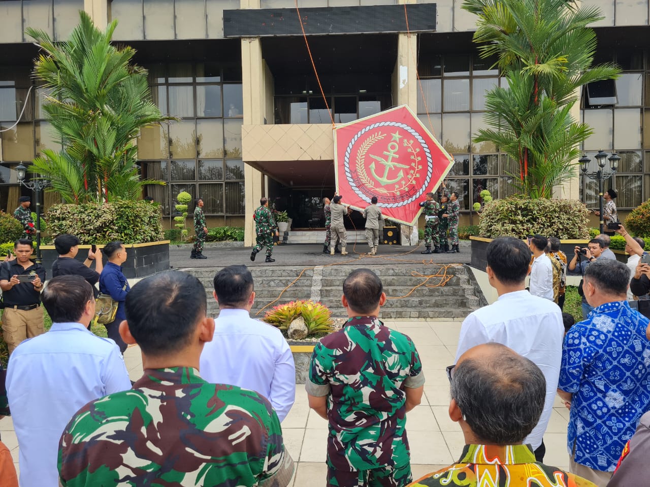 POLEMIK BERAKHIR: Sejumlah anggota menurunkan logo Akademi TNI yang sebelumnya dipasang di gedung utama kantor wali kota, Jumat (14/11/2025).&nbsp;