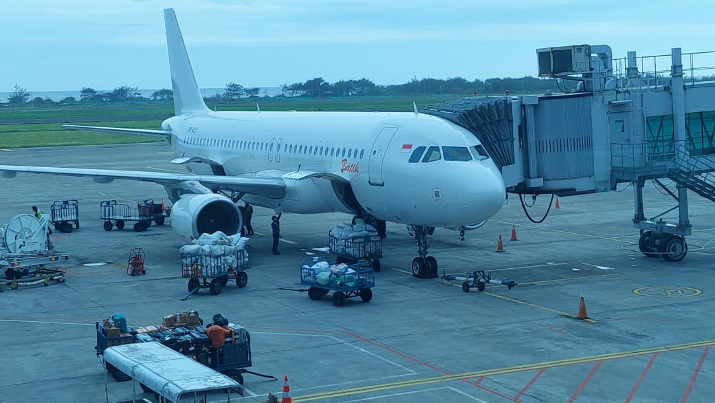PARKIR: Usai mendarat, penumpang pesawat beralih ke terminal kedatangan melalui garbarata.