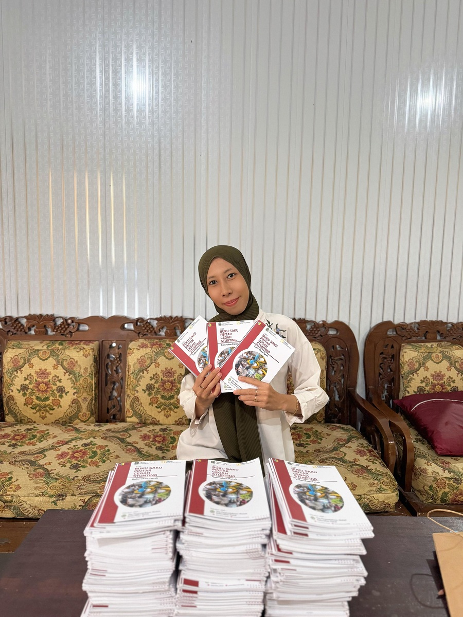 Kepala Perpustakaan Melati Oktavia Eka Purnama sedang menunjukkan buku saku Pintar Cegah Stunting.