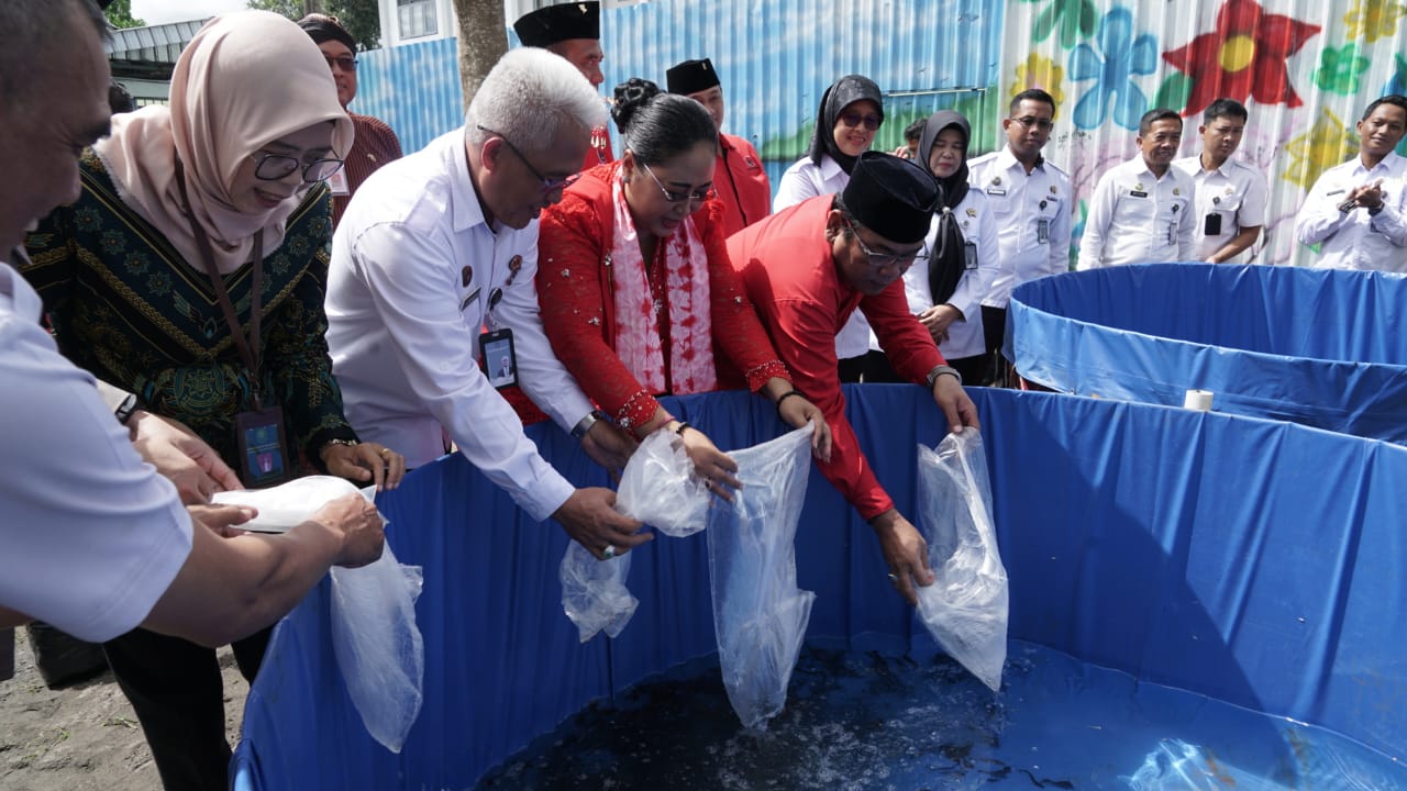 Endah Subekti Kuntariningsih sedang menebar bibit lele di kolam yang dikelola oleh anak binaan lapas.