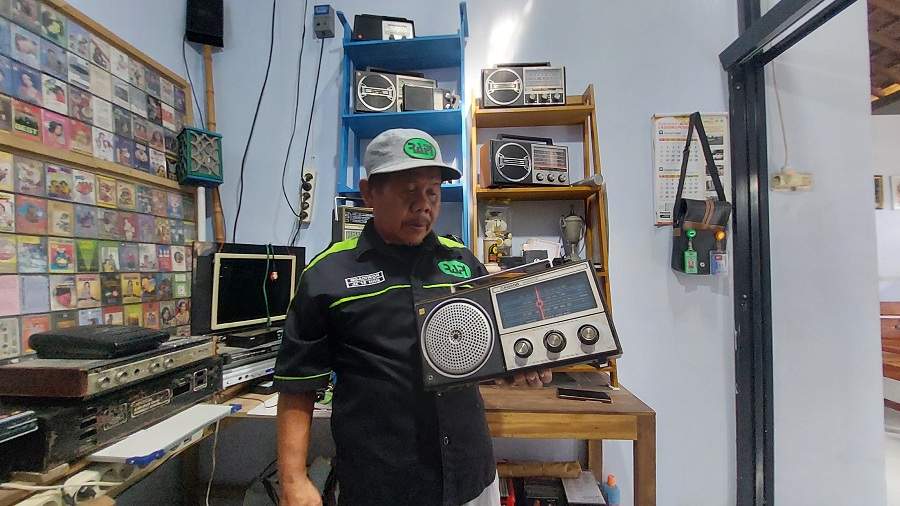 BERSEJARAH: Ngadiwon menunjukkan koleksi radio jadul miliknya.