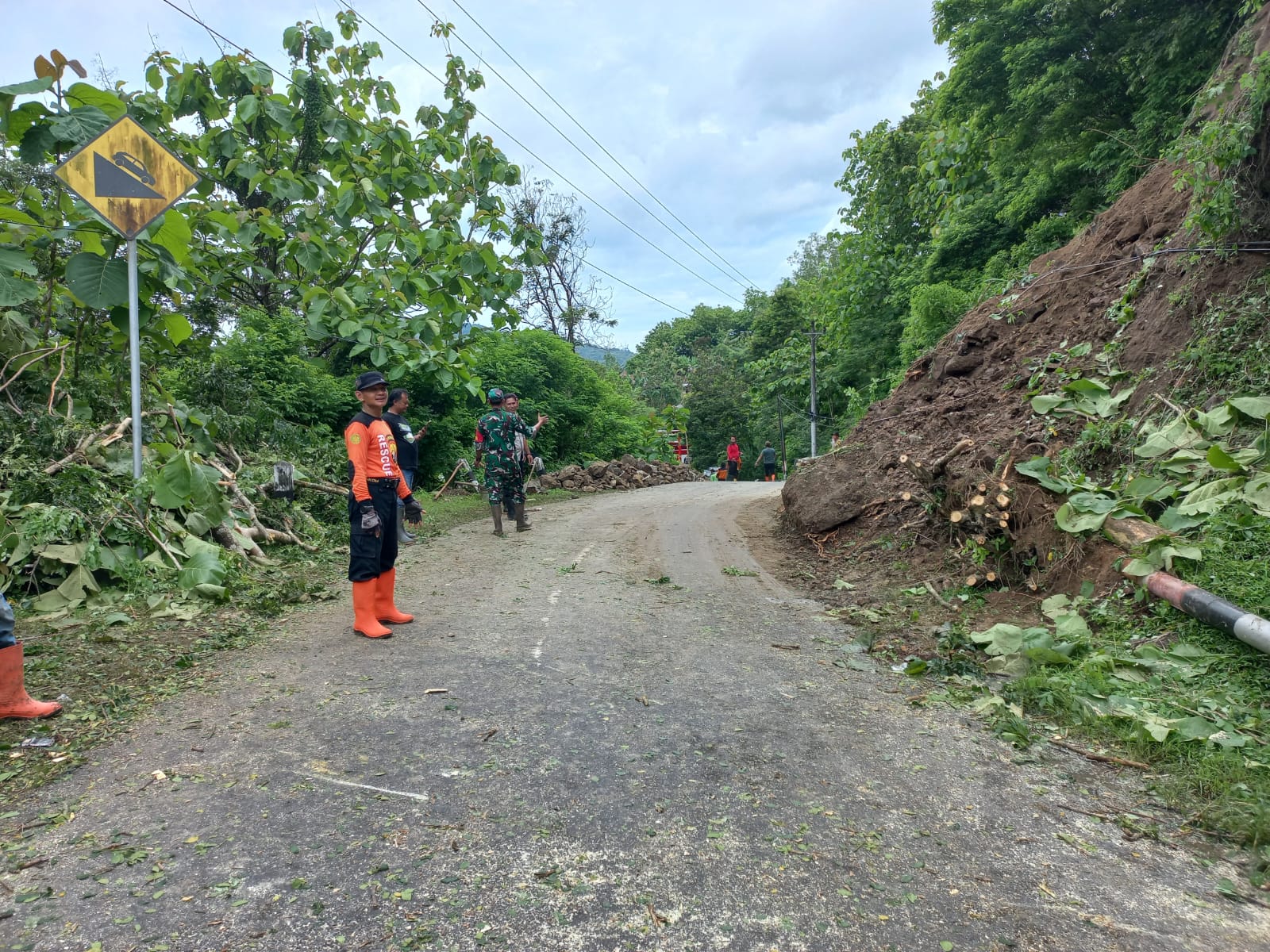 BPBD Gunungkidul bersama pihak kapanewon dan kalurahan sedang membersihkan material longsor di area jalan.