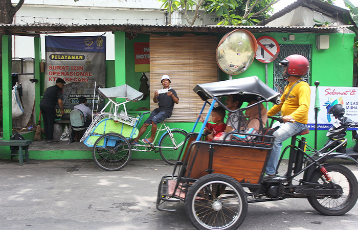 YANG LEGAL DAN ILEGAL: Becak motor (betor) melintas di tempat pengurusan SIOKTB becak. Foto kiri, pembecak menunjukkan &rdquo;STNK&rdquo; becak itu dan petugas dishub menempelkan stiker identitas pembecak.