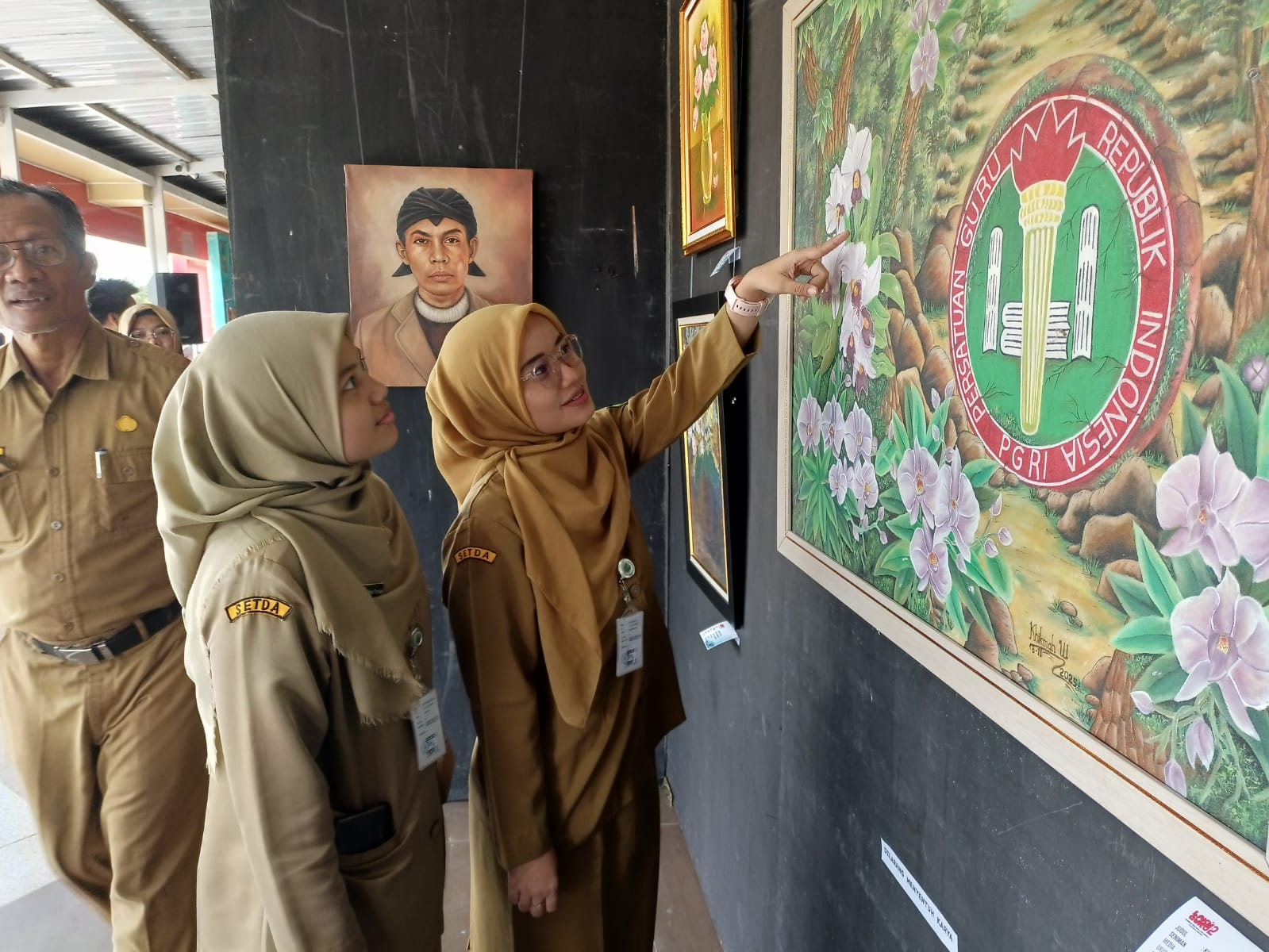 Pengunjung antusias menyaksikan lukisan hasil karya guru di geladak lantai dua Kapal Mendoan, Senin (24/11).
