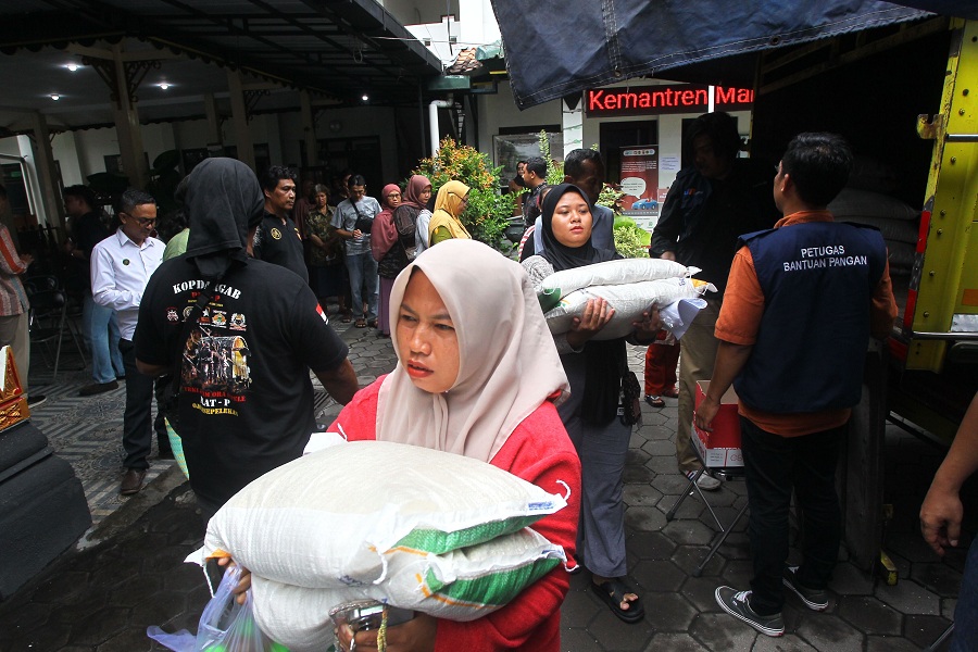 Warga menerima bantuan Cadangan Pangan Pemerintah (CPP) berupa beras dan minyak goreng di Kantor Kemantren Mantrijeron, Rabu (26/11/2025).