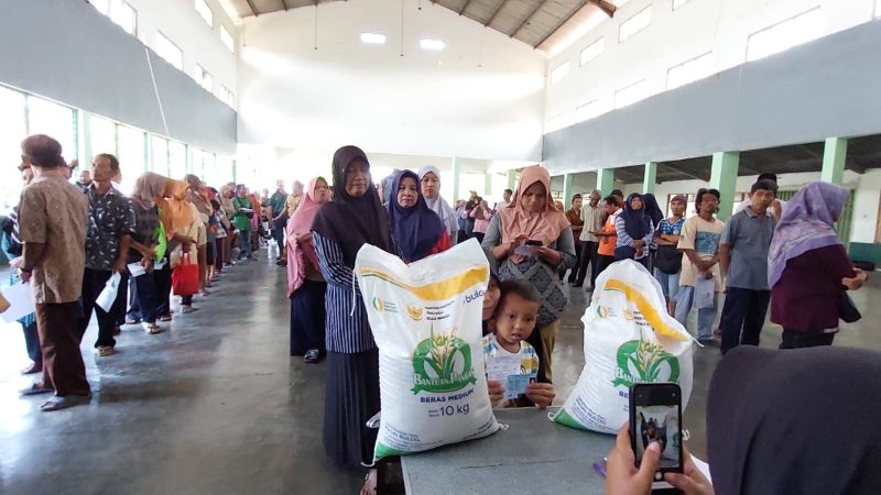 BANTUAN: Penerima bantuan sosial dari pemerintah pusat mengambil beras.&nbsp;