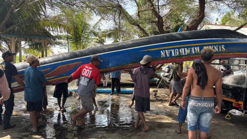 EVAKUASI: Warga bergotong-royong mengevakuasi perahu nelayan asal Kecamatan Ayah yang terbalik setelah dihantam ombak perairan Desa Tanggulangin, Kecamata Klirong.