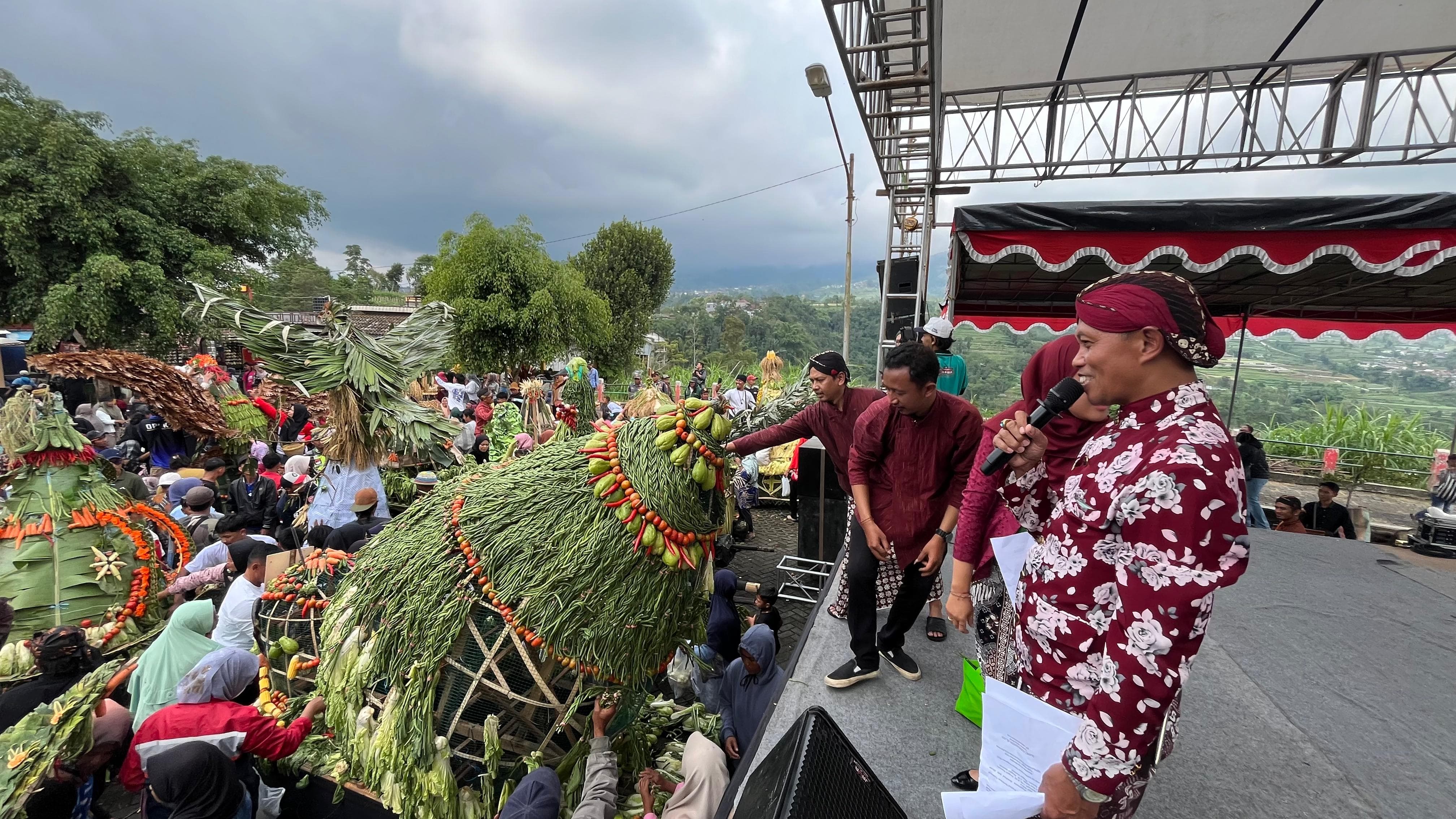 Warga mengambil beberapa hasil bumi pada gelaran festival gunungan di Ketep Pass, Selasa (2/12).