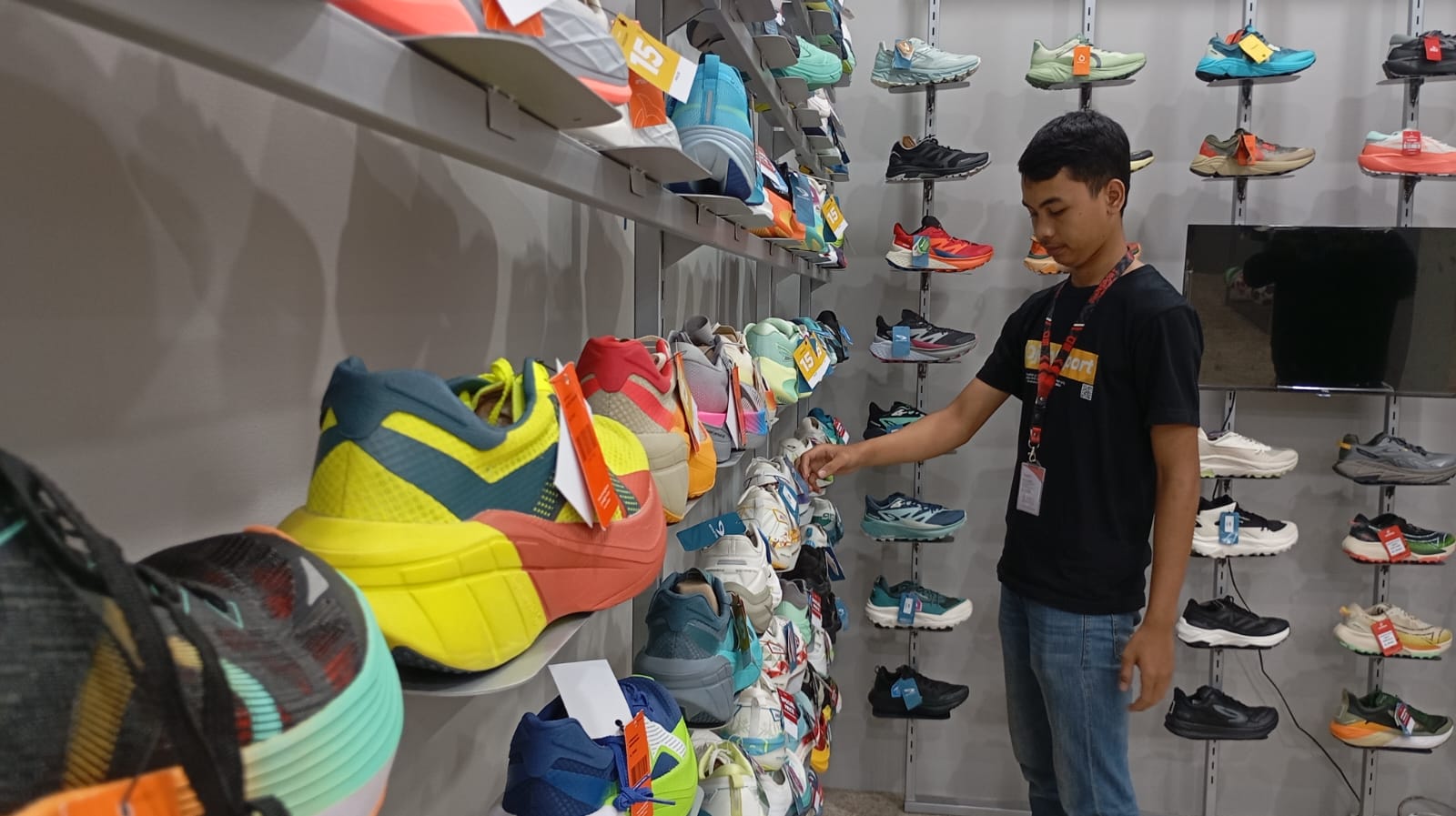 TREN: Karyawan toko sepatu Ojan Sport Indonesia saat menunjukkan produk-produk sepatu lokal di tokonya yang beralamat di Jalan Mojo, Gondokusuman, Selasa (2/12/2025).