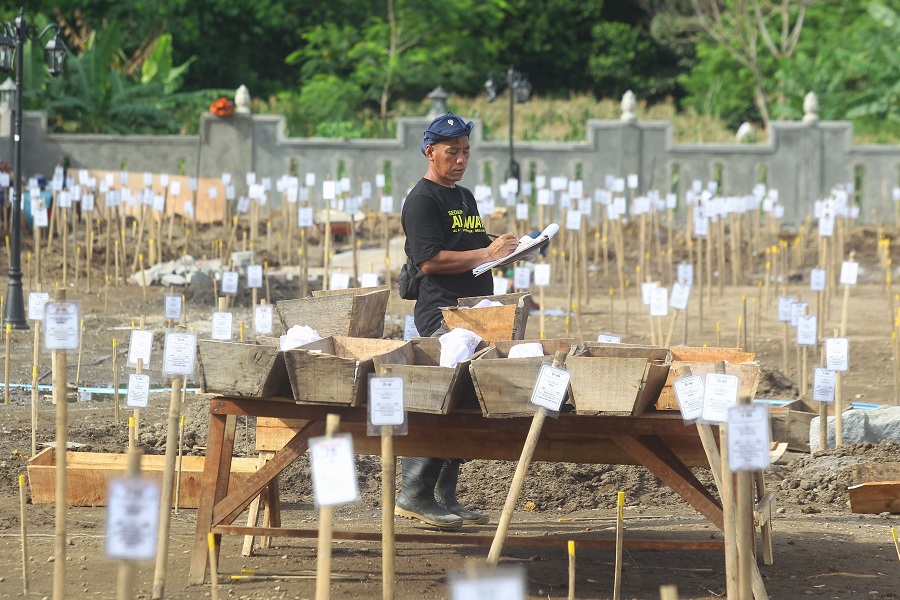 Pekerja menyelesaikan proses relokasi makam di Padukuhan Kaweden, Tirtoadi, Mlati, Sleman, DIY, Rabu(3/12/2025).