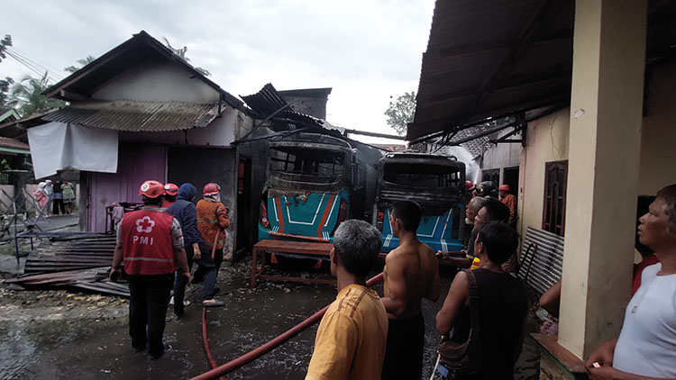 BERJIBAKU: Personel Damkarmat Kulon Progo mencoba memadamkan api yang membakar dua bus tanggung.