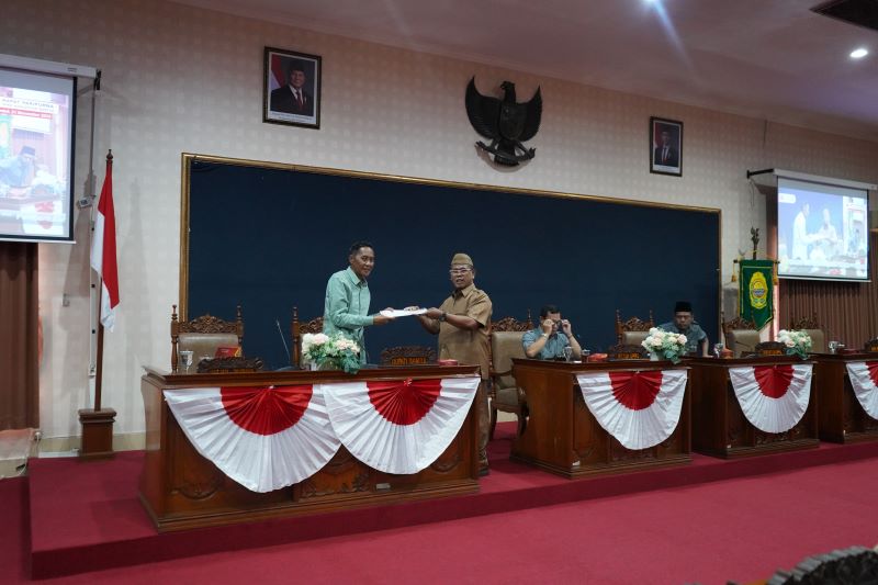 Ketua Bapemperda DPRD Bantul Suwandi (kanan) menyerahkan dokumen Propemperda 2026 kepada Wakil Bupati Bantul Aris Suharyanta usai rapat paripurna pengambilan keputusan Propemperda