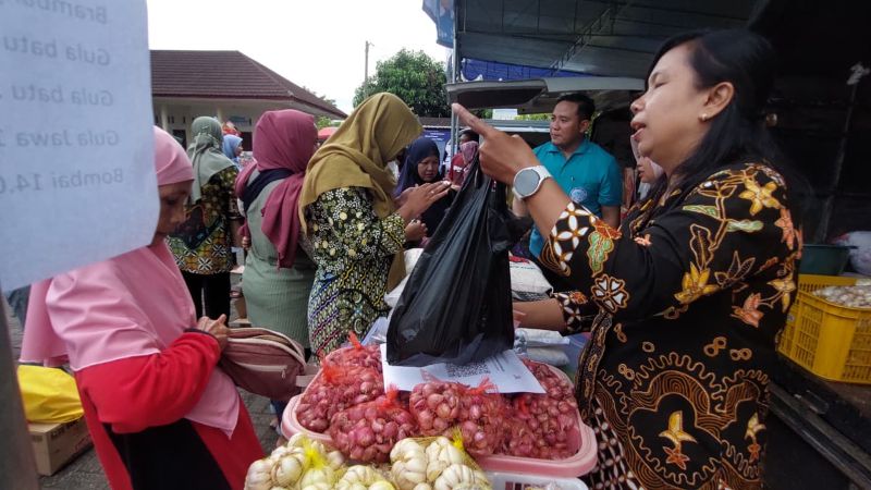 Pegawai Perumda Aneka Usaha menjual barang hasil panen dari petani di Pasar Murah.&nbsp;