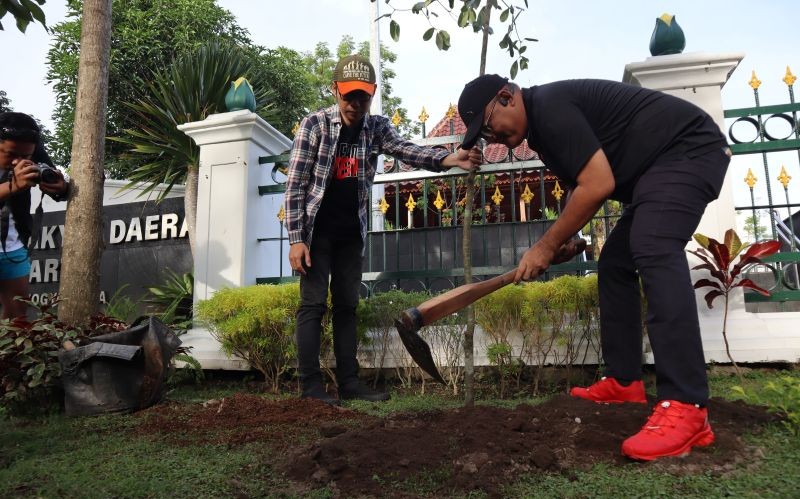 TANAM: Ketua DPRD Kota Jogja Wisnu Sabdono Putro saat menanam bibit pohon sawo kecik di halaman depan kantornya pada Sabtu (13/12/2025).&nbsp;
