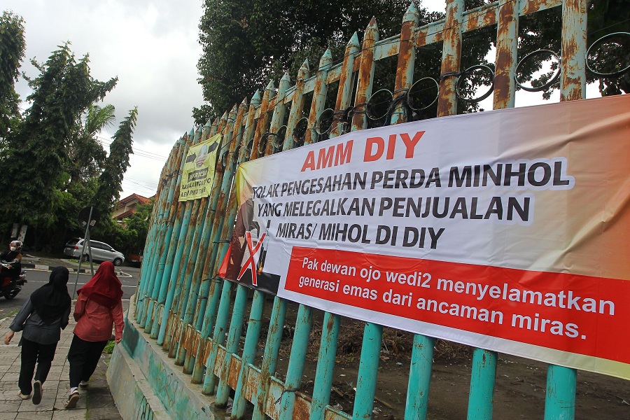 Spanduk berisi penolakan terhadap pelegalan minuman keras atau minuman beralkohol terpasang di pagar Stadion Mandala Krida, Kota Jogja, Senin (15/12/2025).