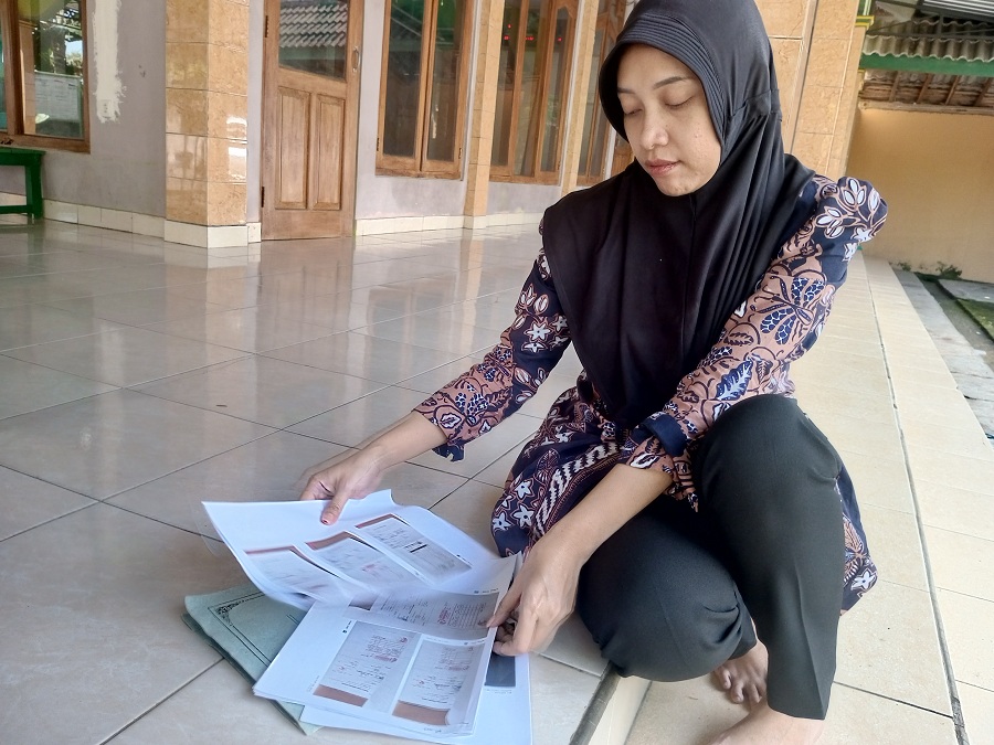 Bendahara Kalurahan Ngunut Noviana Nur Fatimah sedang menunjukkan bukti-bukti berupa nota fiktif.