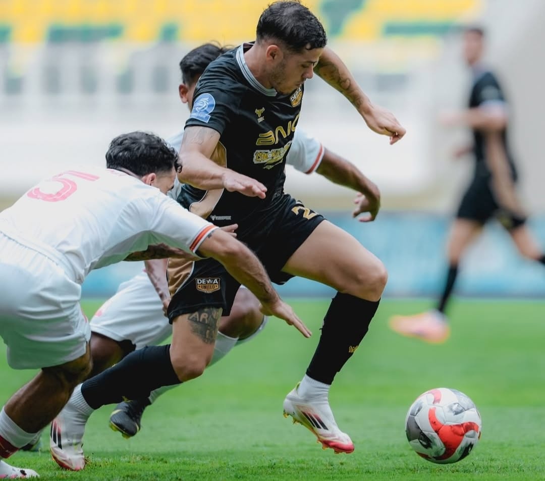 Pemain Dewa United, Alexis Messidoro (seragam hitam) saat coba lewati hadangan pemain Persis Solo