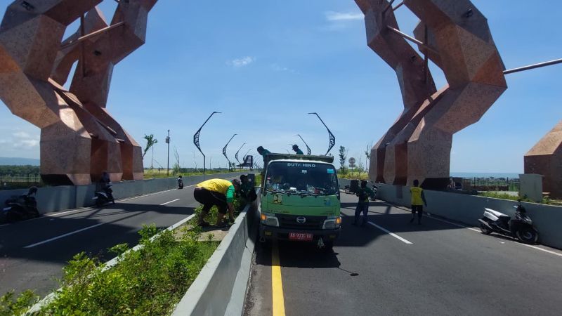 BERSIH: Petugas DLH memungut sampah di area taman Jembatan Kabanaran.&nbsp;