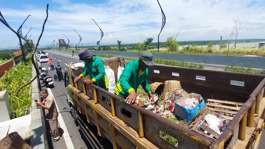 BERSIH: Petugas DLH memungut sampah di area taman Jembatan Kabanaran.