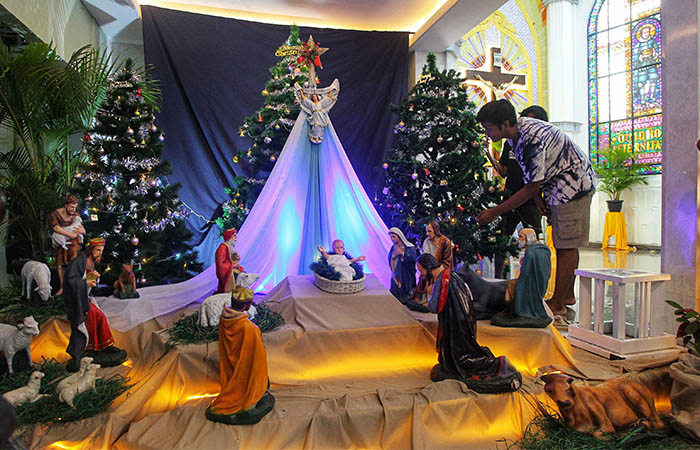 Panitia menata dekorasi di altar Gereja Katolik Santo Aloysius Gonzaga, Mlati, Sleman, Selasa (23/12/2025). Sejumlah persiapan seperti memasang bunga dan pembersihan dilakukan di gereja tersebut.