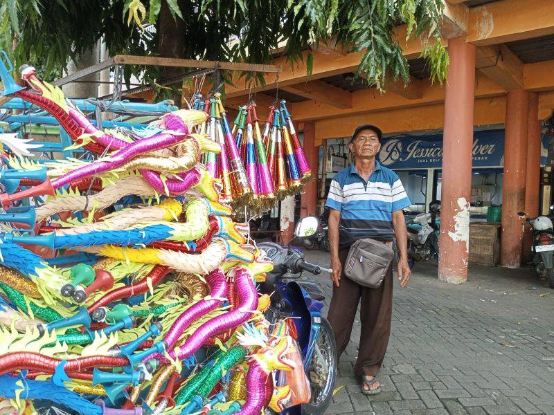 Suradi, pedagang trompet yang mangkal di depan pasar Argosari, Gunungkidul.&nbsp;