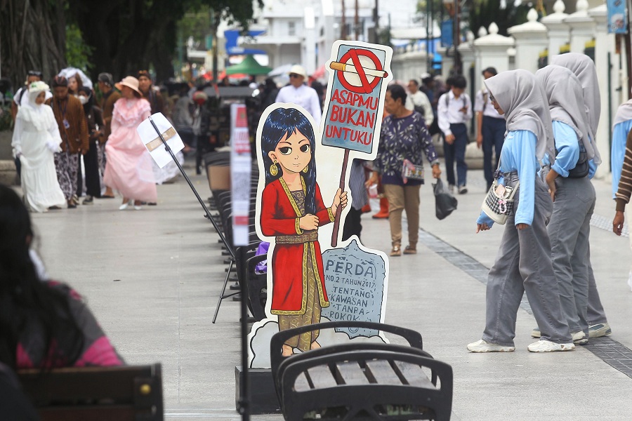 Wisatawan melintas di dekat ornamen berisi informasi tentang Kawasan Tanpa Rokok (KTR) di Titik Nol Kilometer, Kota Jogja, beberapa waktu lalu.