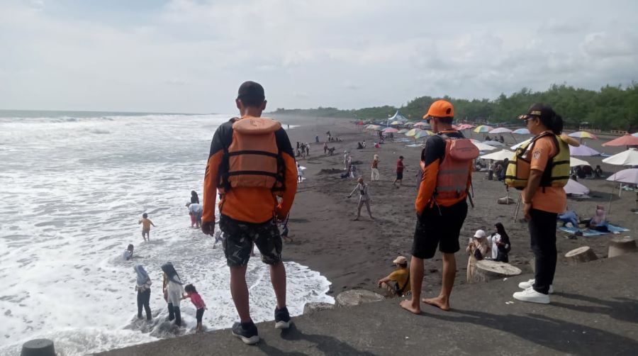 PEMANTAUAN: Personel SAR melihat wisatawan yang bermain di Pantai Glagah.