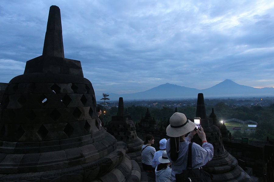 Wisatawan menyaksikan matahari terbit saat program Sunrise Borobudur di Taman Wisata Borobudur, Magelang, Jawa Tengah, Kamis (1/1/2026)