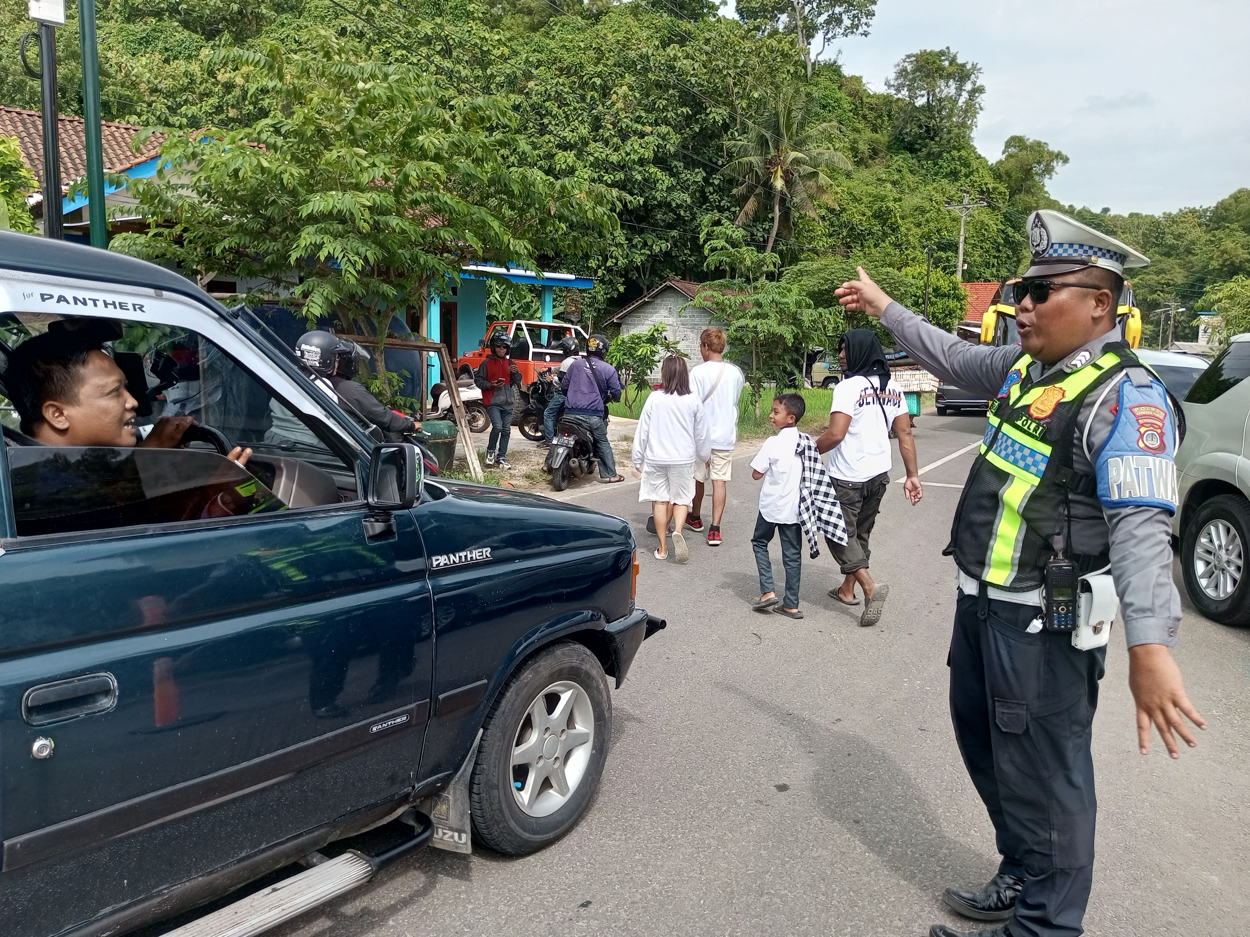 Petugas Satlantas Polres Gunungkidul Brigadir Rian Candra Satria sedang mengatur arus lalu lintas di pertigaan menuju Pantai Drini pada Kamis pagi (1/1).  &nbsp;