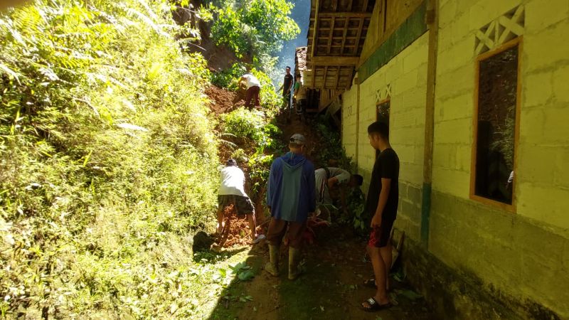 EVAKUASI - Rumah Sandi, warga Hargotirto, Kapanewon Kokap dihantam longsor. Tebing setinggi puluhan meter nyaris mengubur rumah nya. Proses evakuasi dilakukan gotong royong bersawa warga sekitar.