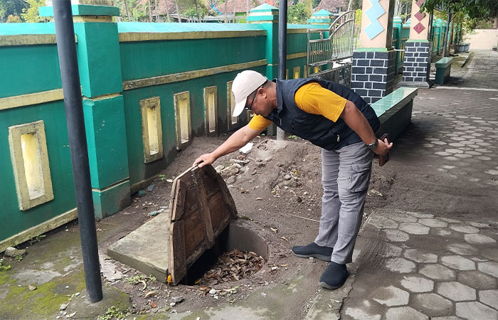 BERGERAK: Guru olahraga SDN Grogol Badri Saronto sedang memantau lubang biopori yang ada di halaman sekolah Jumat (2/1). Sekolah ini mulai mengelola sampah mandiri.