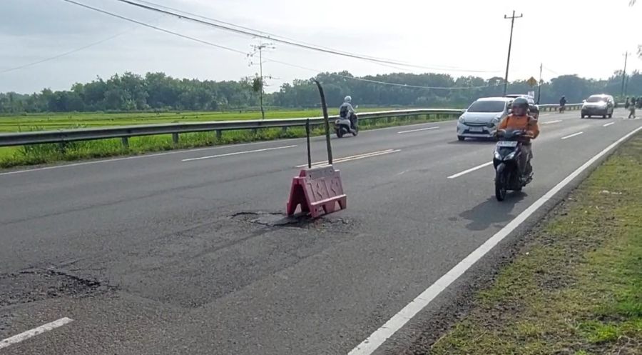 CEPAT: Kendaraan melaju dari arah Jogja ke Wates melewati penanda jalan berlubang.