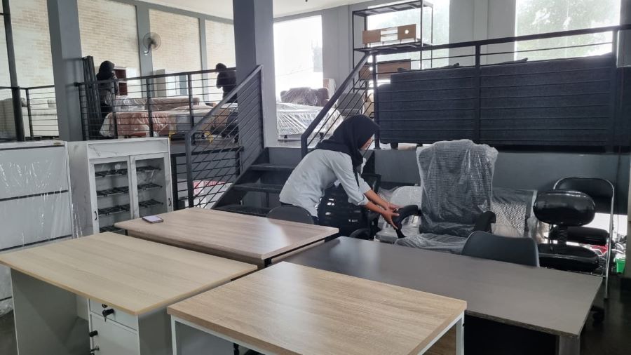 Foto staf Santi Mebel saat menata berbagai produk furniture kantor yang ada di toko