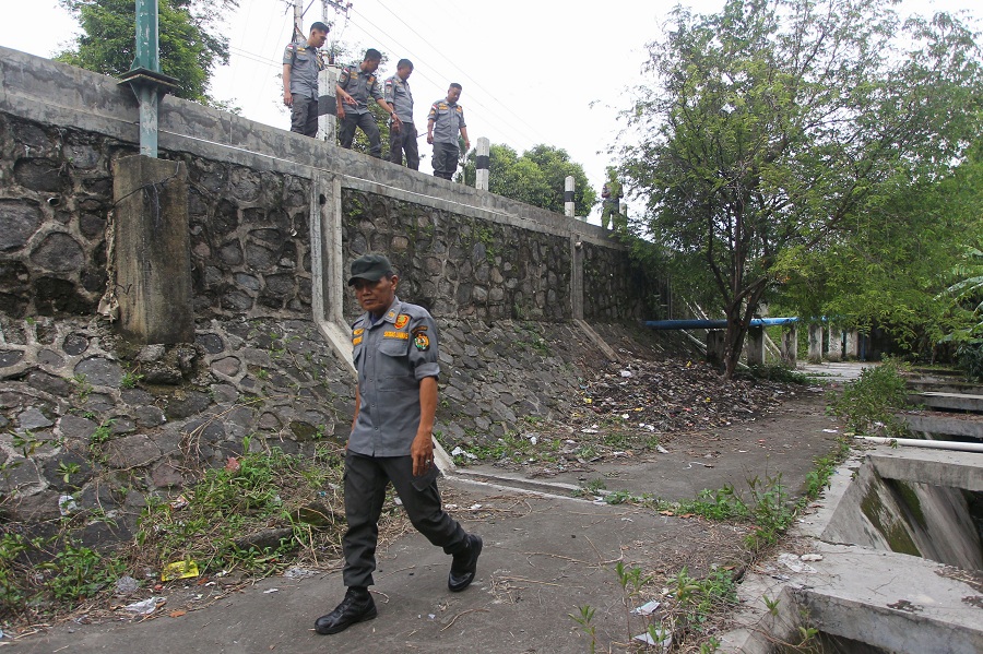 Petugas Linmas Kota Jogja berjaga di lokasi yang sebelumnya dijadikan tempat pembuangan sampah liar, di sisi barat Jembatan Muja-Muju, Kota Jogja, Senin (5/1/2026).