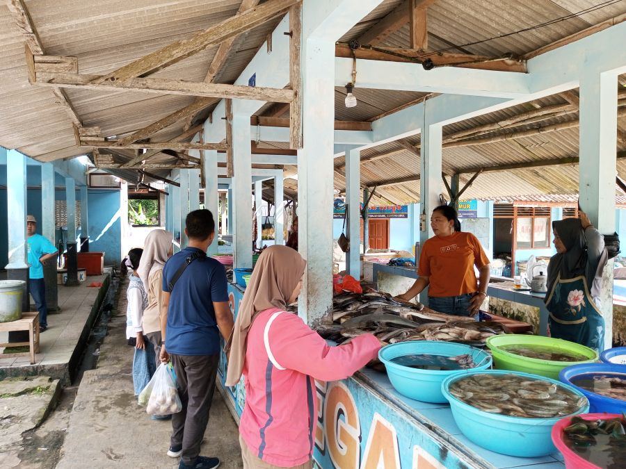 Aktivitas ibu-ibu penjual ikan segar di area Pantai Baron.