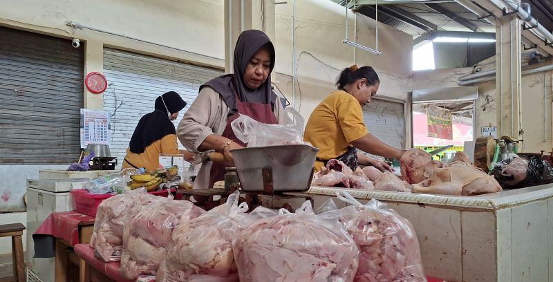 LARIS MANIS: Pedagang daging ayam di Pasar Wates saat menyiapkan potongan daging untuk konsumen.