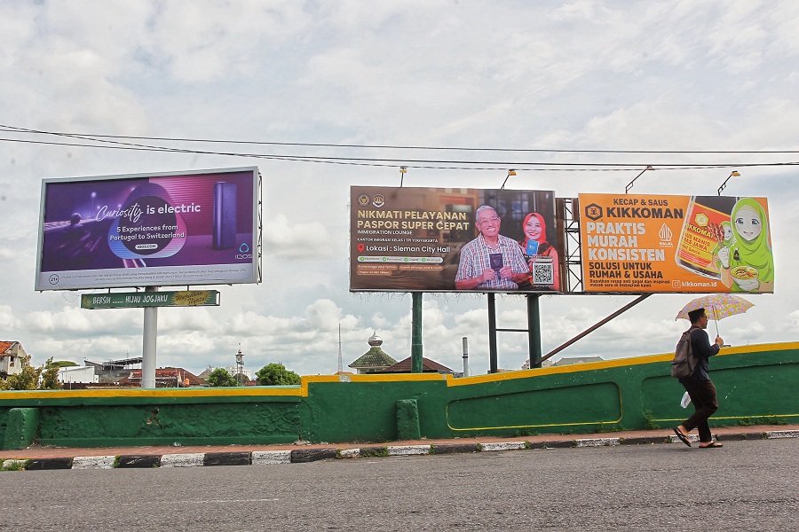 Pengguna jalan melintas di dekat reklame billboard yang terpasang di sisi selatan Jembatan Kewek, Kota Jogja, kemarin (8/1/2026).