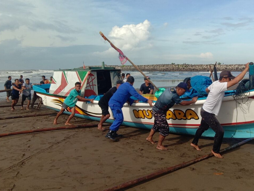 Petugas TNI-Polri bersama relawan berhasil mengevakuasi perahu nelayan yang terbalik di area pemecah ombak Pantai Logending, kemarin. (Dokumentasi Polres Kebumen)