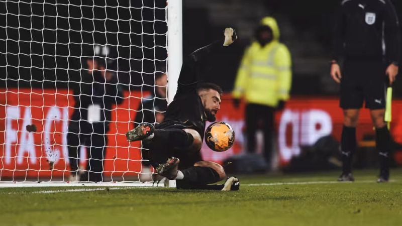 Kiper Oxford United, Matt Ingram saat menggagalkan tembakan penalti dari pemain MK Dons di FA Cup