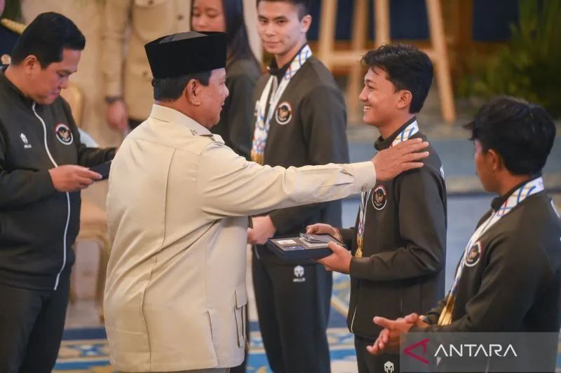 Presiden Prabowo Subianto didampingi Menpora Erick Thohir menyerahkan buku tabungan kepada Basral Graito - Sumber: Antara News / Antara Foto