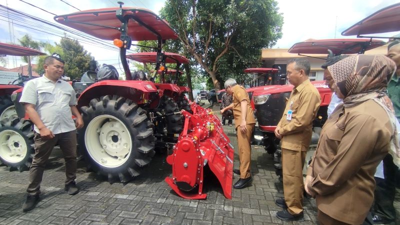 Bupati Bantul Abdul Halim Muslih sedang menuangkan air ke traktor sebagai simbolis pemberian alsistan ke gapoktan di halaman DKPP Bantul Senin (12/1)