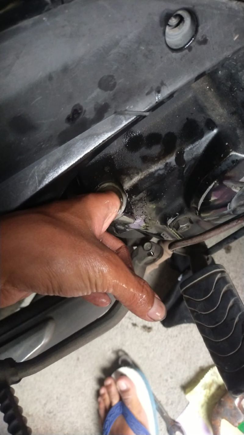 Tangan pria di Trimulyo, Jetis, Bantul yang masuk ke dalam lobang bak oli motornya Selasa (13/1)