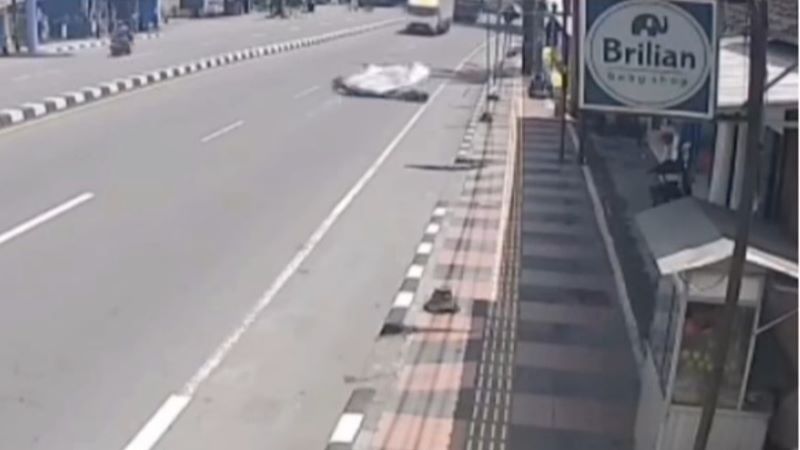 TERJATUH: Pengendara sepeda motor terkena banner yang jatuh di Salam Rabu (14/1).