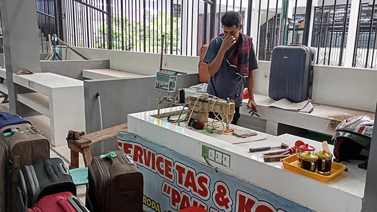 ROMBAK: Pemilik jasa servis tas dan koper Pak Is Yunus Wahyu saat merenovasi losnya di Pasar Terban, Kamis (15/1/2026). Los yang disediakan dinilai kurang layak.