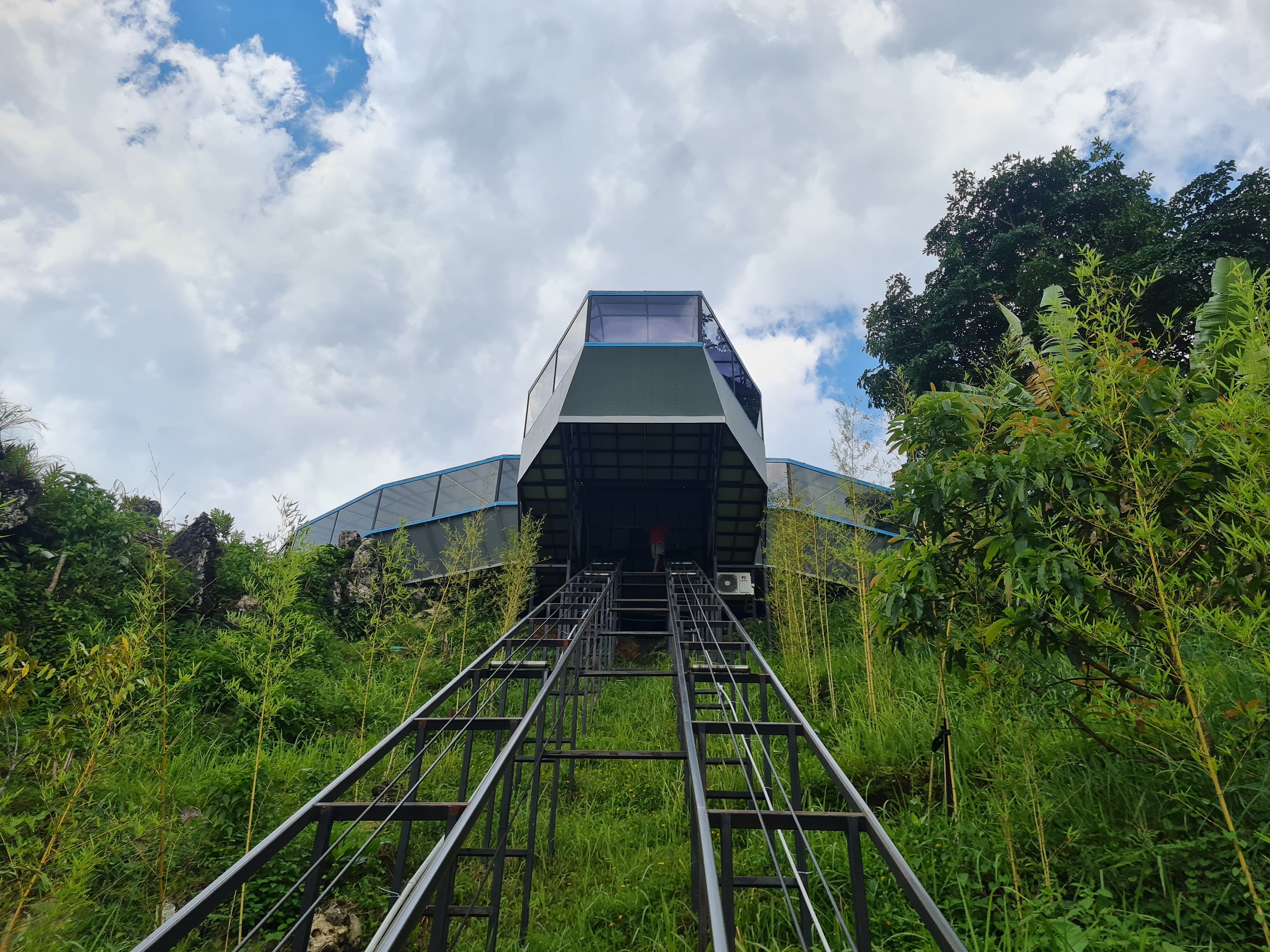 Pengunjung dapat menaiki lift untuk menuju ke UFO Menoreh dan akan disuguhi hamparan sawah dan batu marmer.