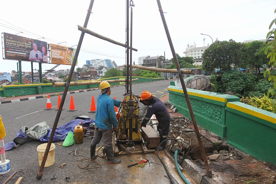 Pekerja menyelesaikan proses pengambilan sampel tanah untuk diuji di laboratorium sebagai bagian dari kajian teknis pembangunan Jembatan Kewek, Kota Jogja, Minggu (18/1/2026).