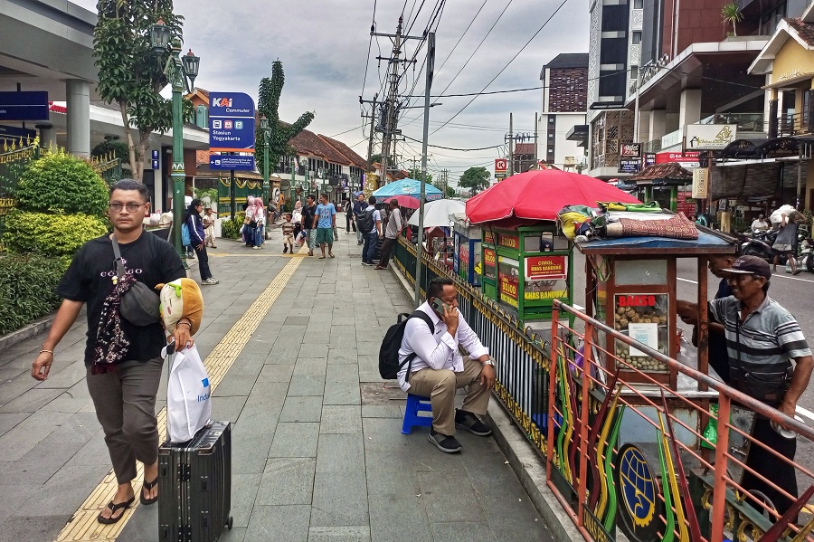 Pedagang kaki lima (PKL) berjualan makanan dan minuman di Jalan Pasar Kembang, tepat di sisi selatan Stasiun Tugu Jogja, Rabu (21/1/2026).