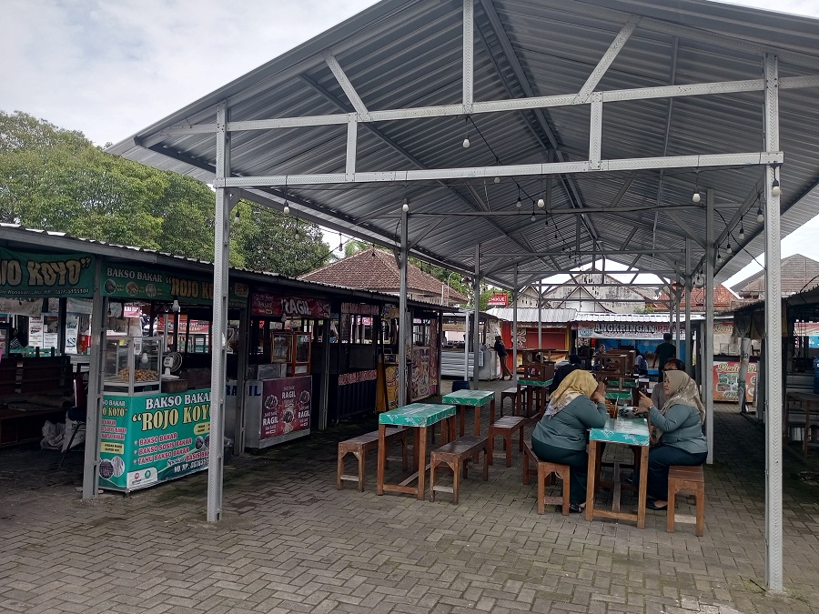 Pengunjung Taman Kuliner Wonosari terlihat sedang menyantap jajan yang dibelinya.