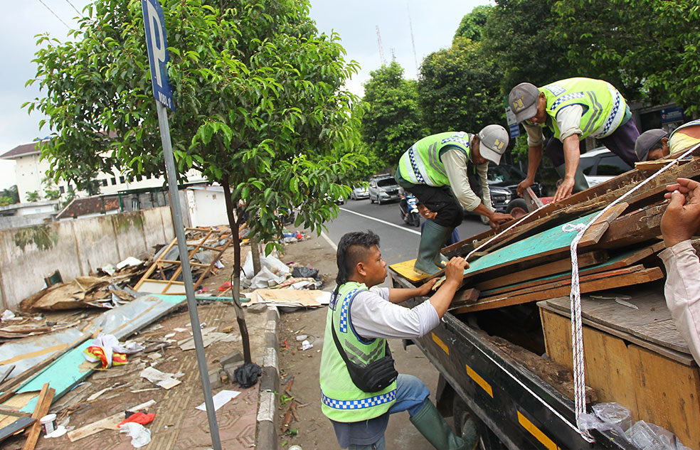 Pekerja mengangkut bekas bangunan lapak pedagang buku yang sudah dibongkar di Jalan Kahar Muzakir, Kota Jogja, kemarin (22/1).