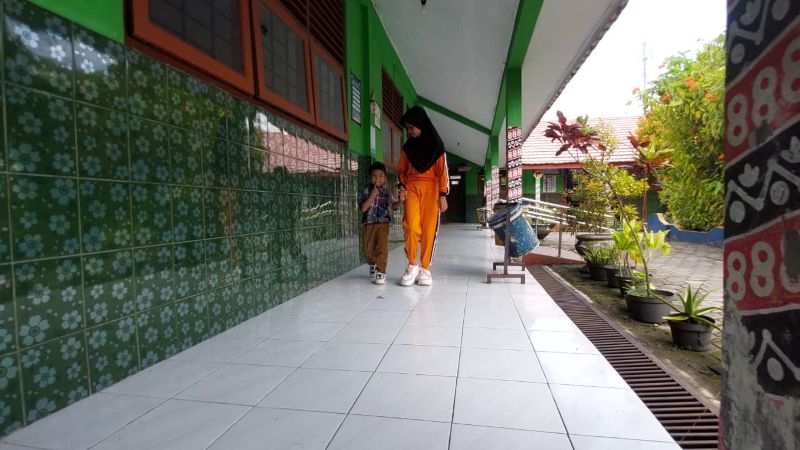 PENUH PERJUANGAN: Ralea dan adiknya berjalan beriringan menuju kelas.